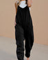 Black jumpsuit worn by a person against a beige background