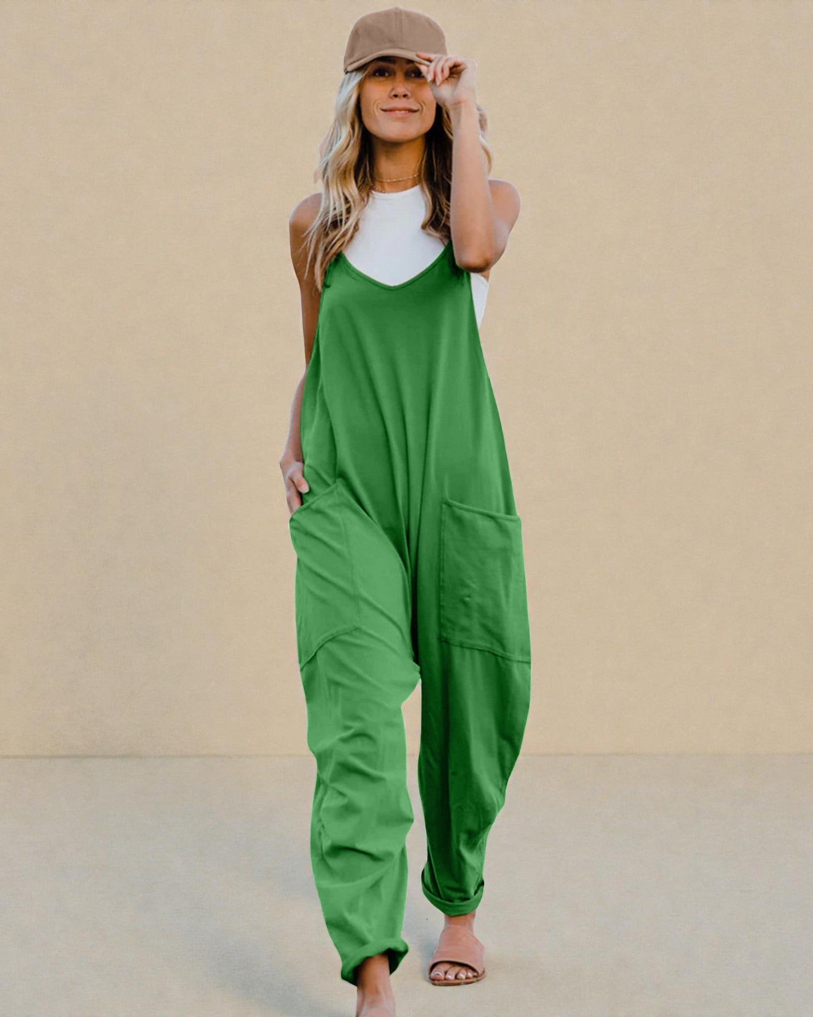 Person wearing a green jumpsuit and white top against a beige background