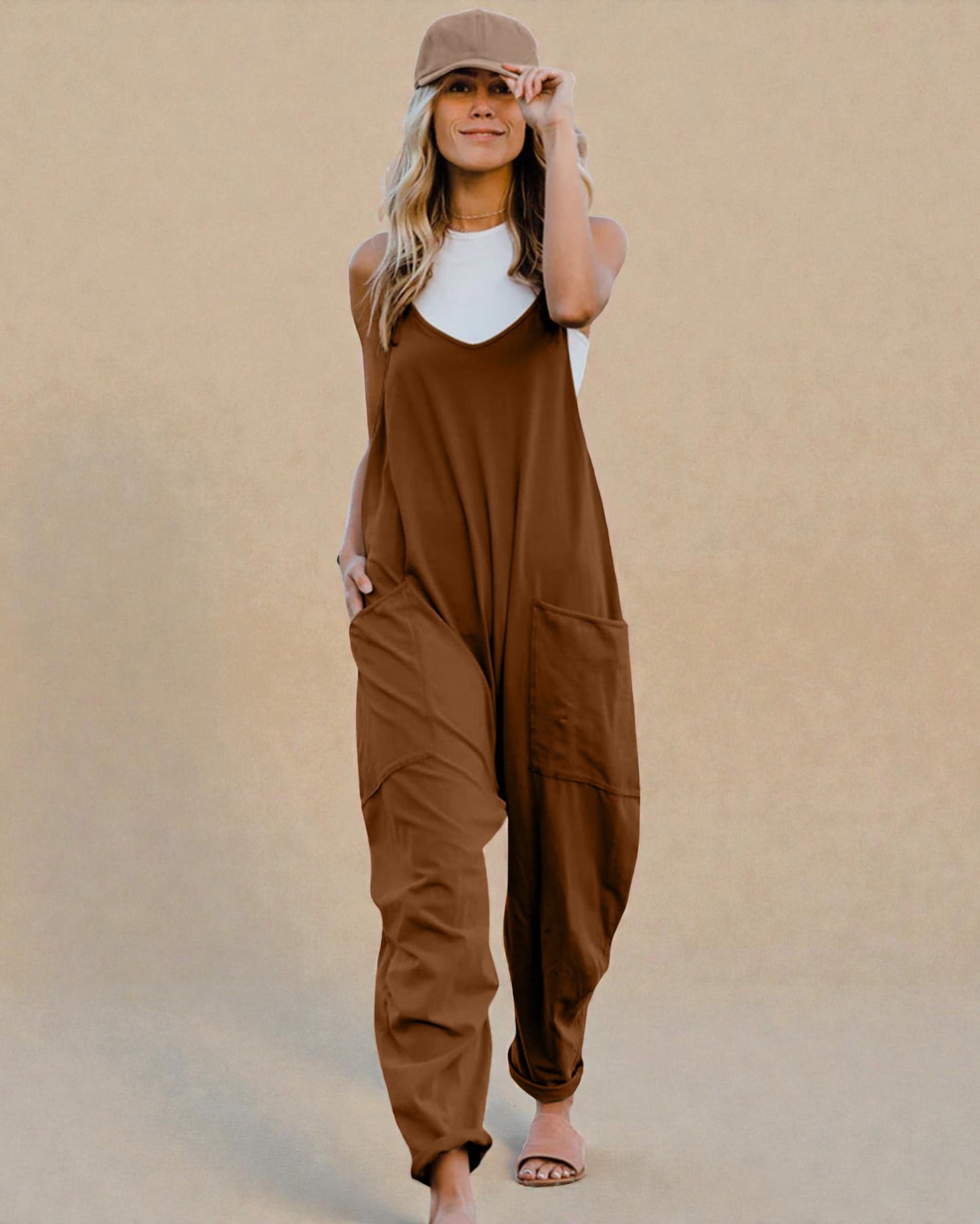 Woman wearing a brown jumpsuit against a beige background