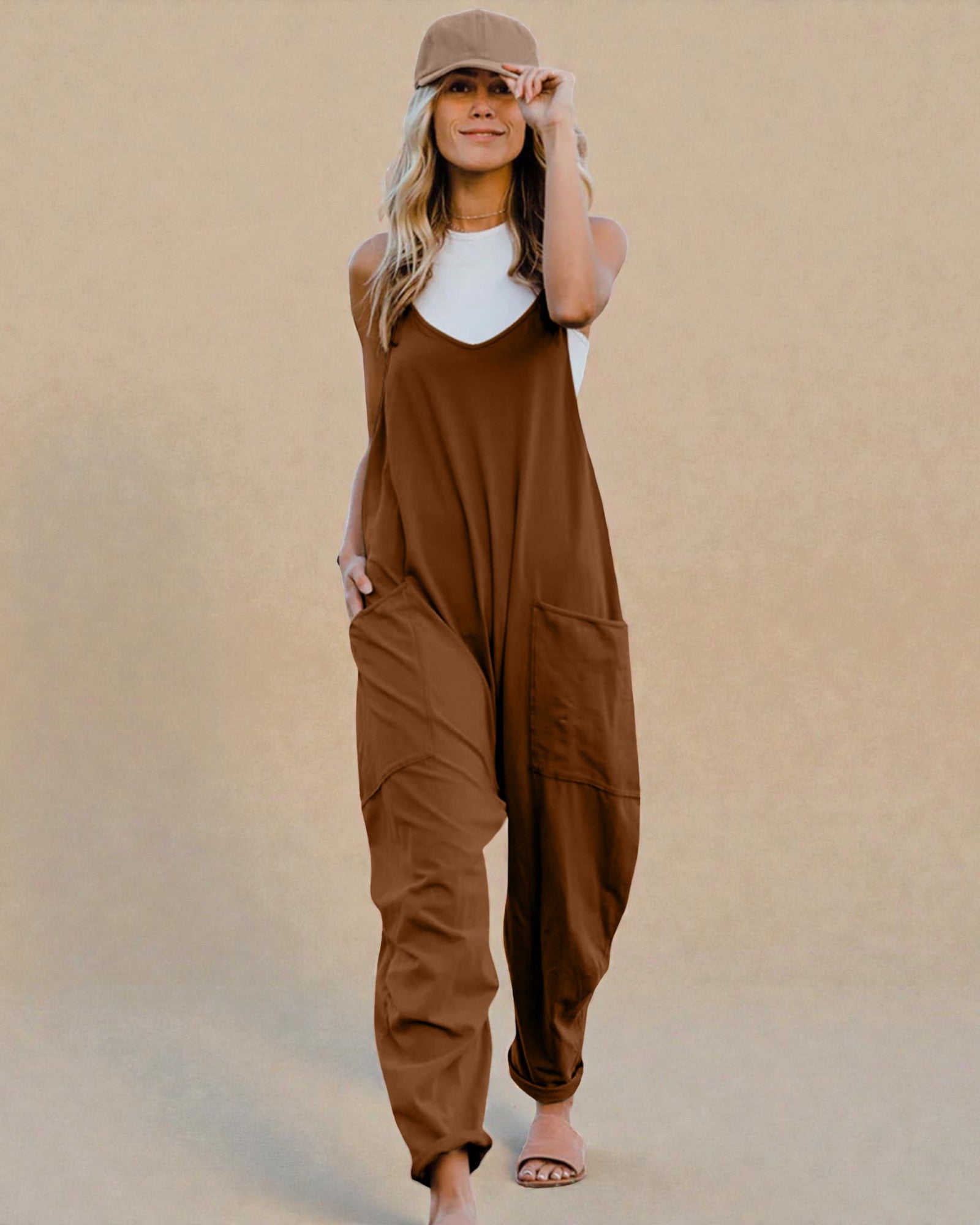 Woman wearing a brown jumpsuit against a beige background