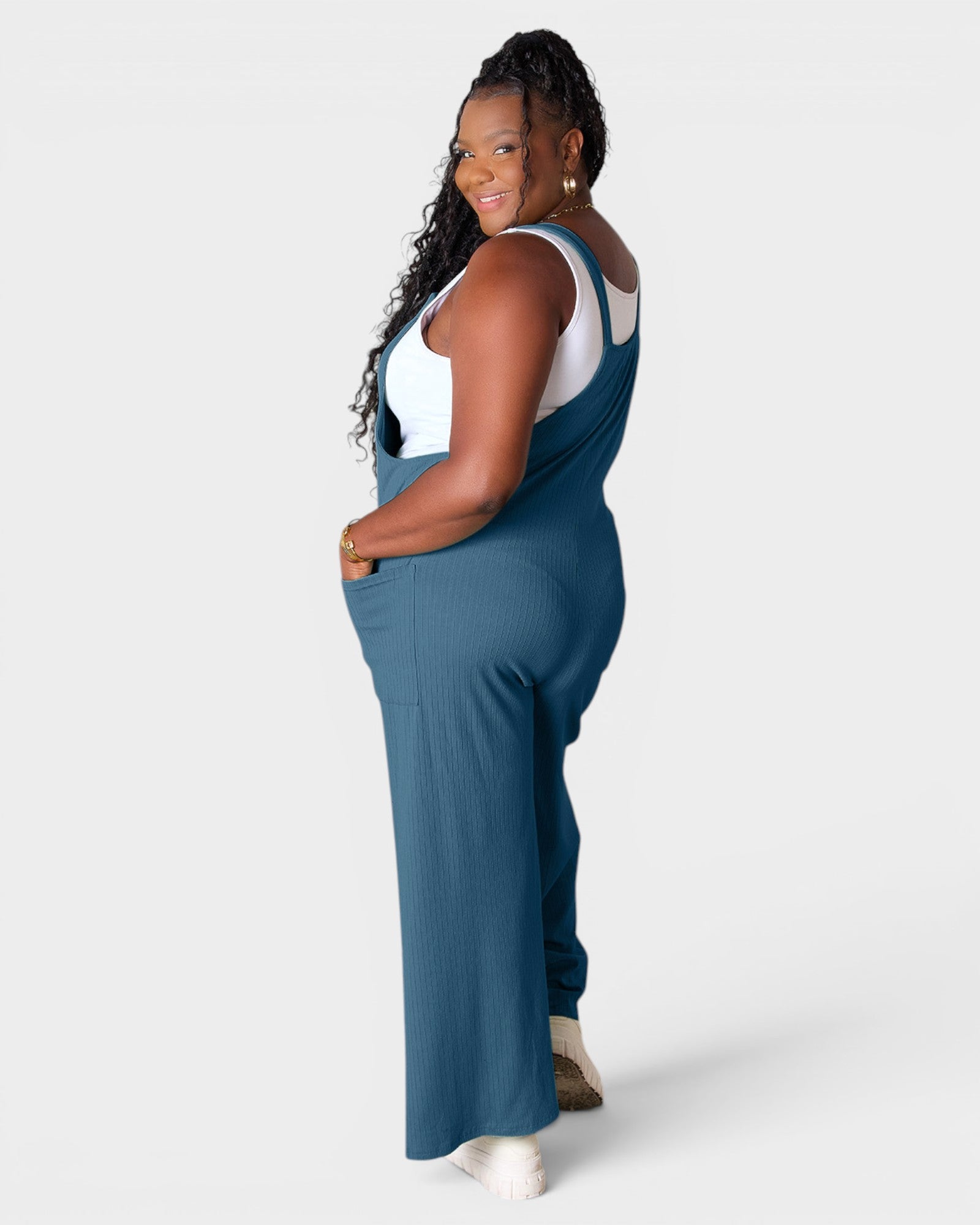 Woman wearing blue overalls on a white background