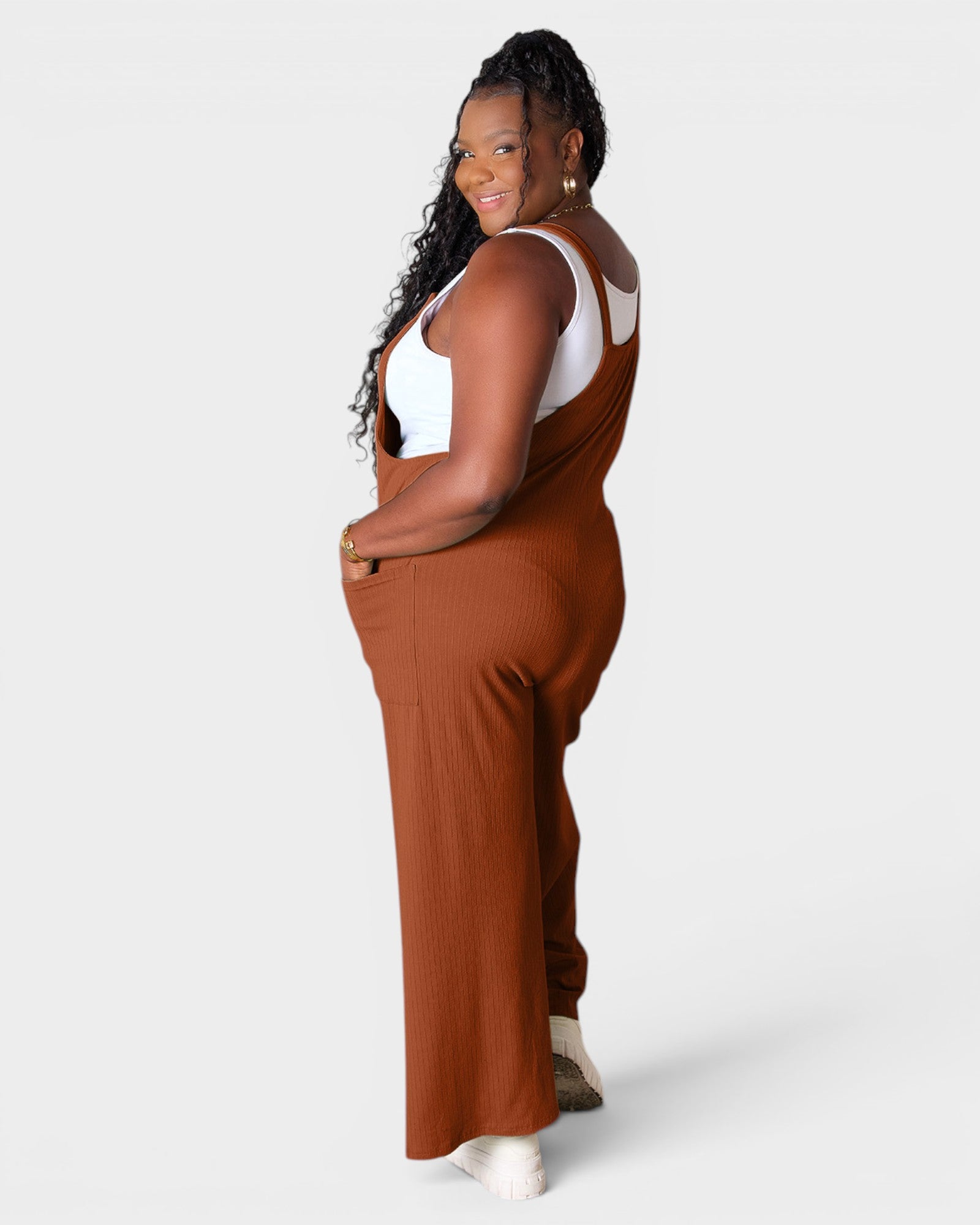 Woman wearing brown overalls on a white background