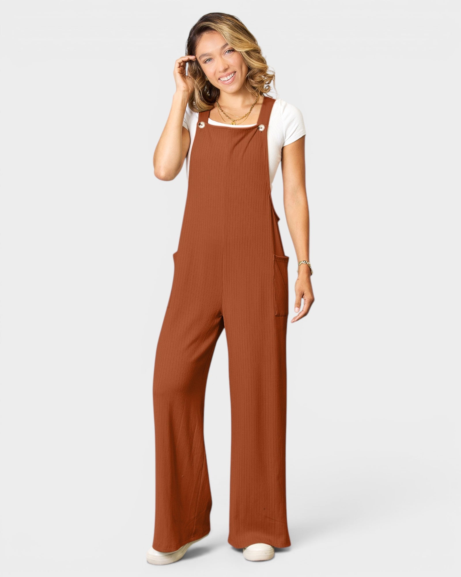 Woman wearing a brown jumpsuit on a white background