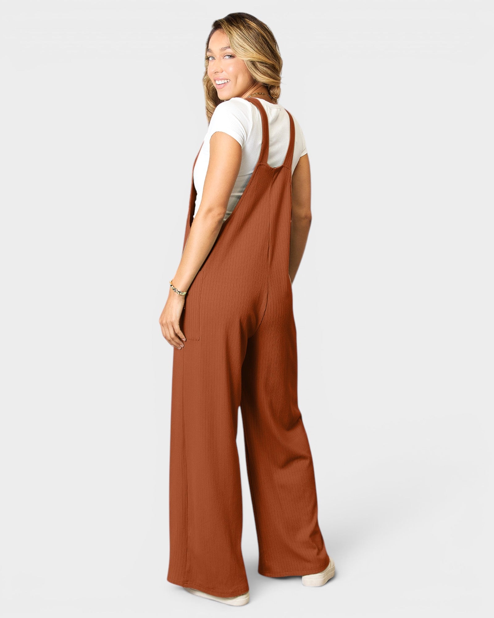 Woman wearing a brown jumpsuit on a white background