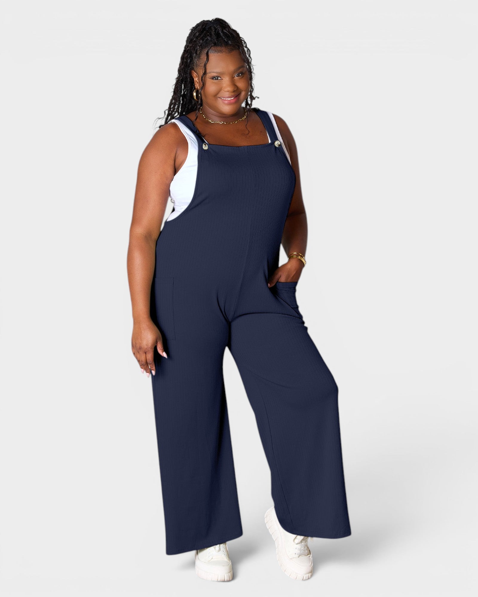 Woman wearing a navy blue jumpsuit on a white background