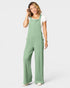 Woman wearing a green ribbed jumpsuit on a white background