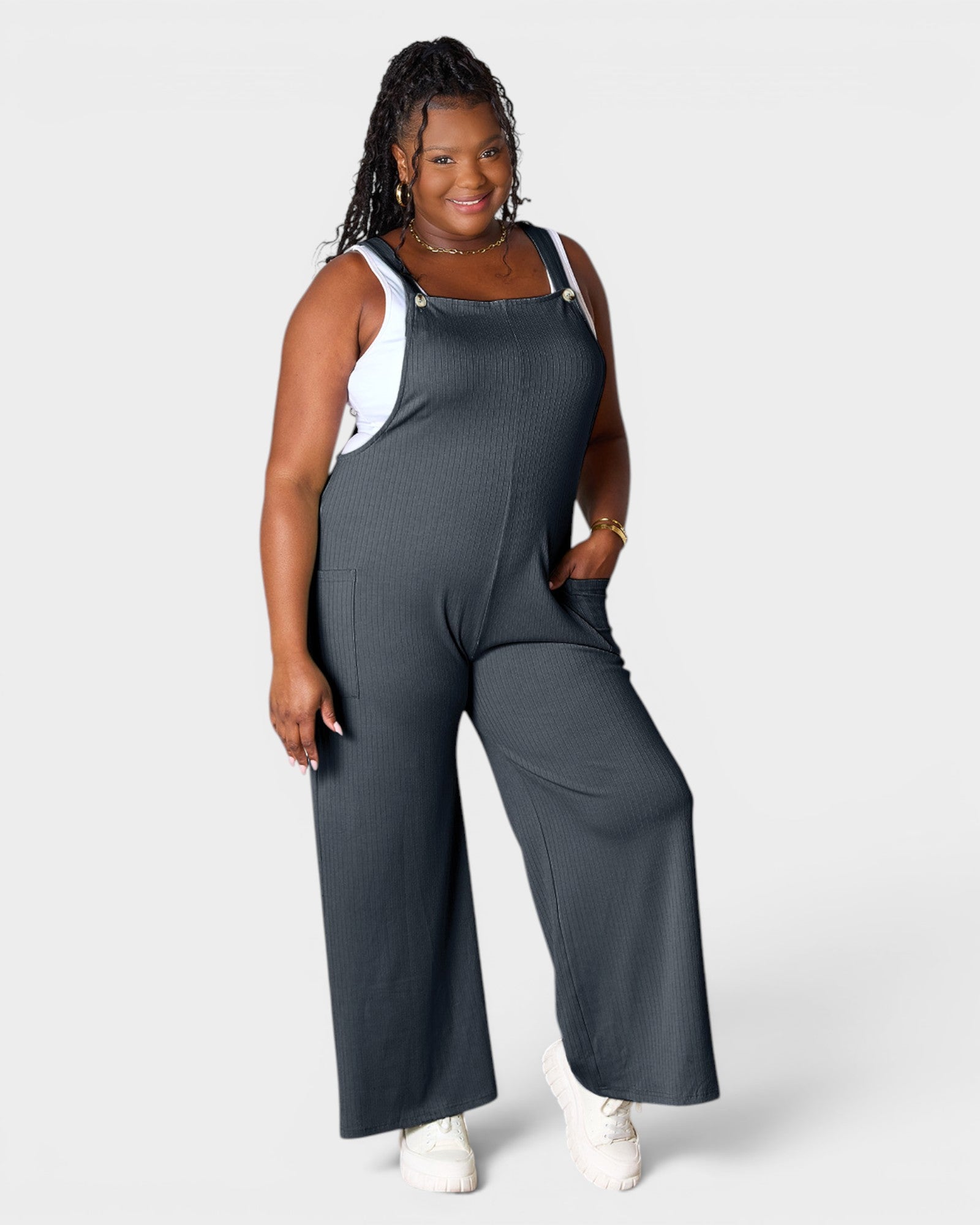 Woman wearing a gray jumpsuit on a white background