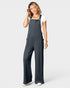Woman wearing a dark gray ribbed jumpsuit on a white background