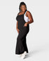 Woman wearing a black dress over a white top on a plain background