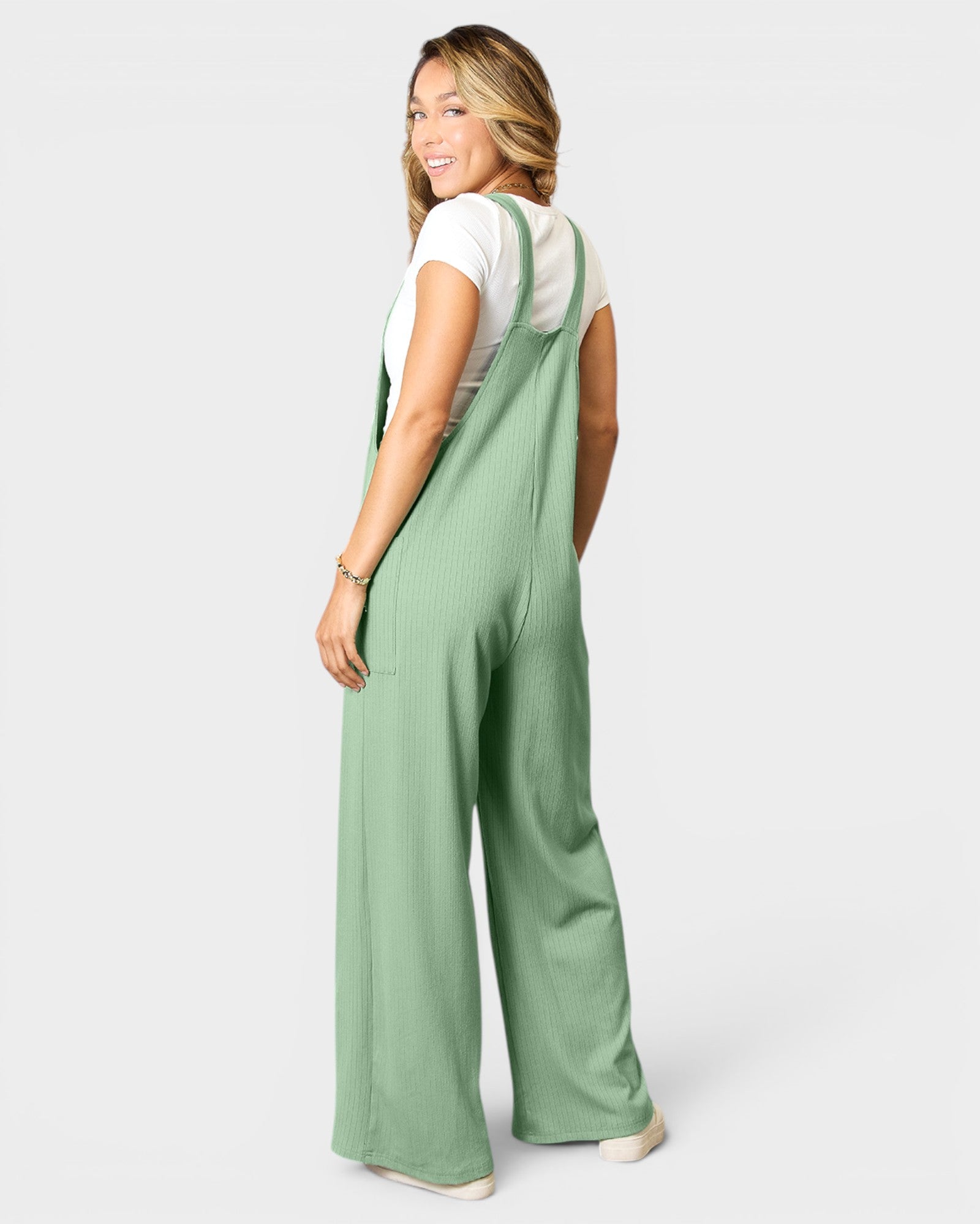 Woman wearing green checkered overalls on a white background