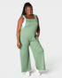 Woman wearing a green ribbed jumpsuit on a white background