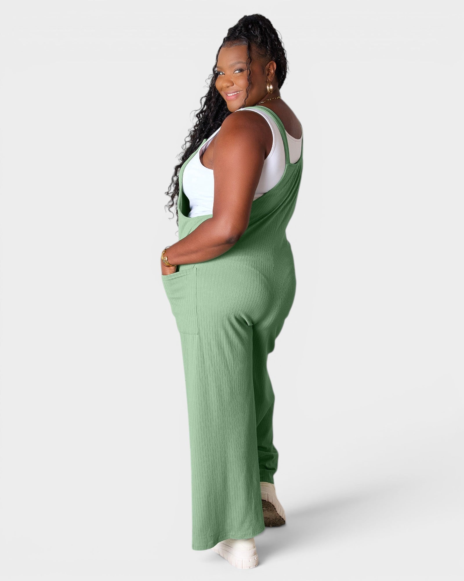 Woman wearing green overalls on a white background