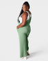 Woman wearing green overalls on a white background