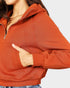 Person wearing a rust-colored hoodie with a white background