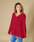 Woman wearing a red blouse with a beige background