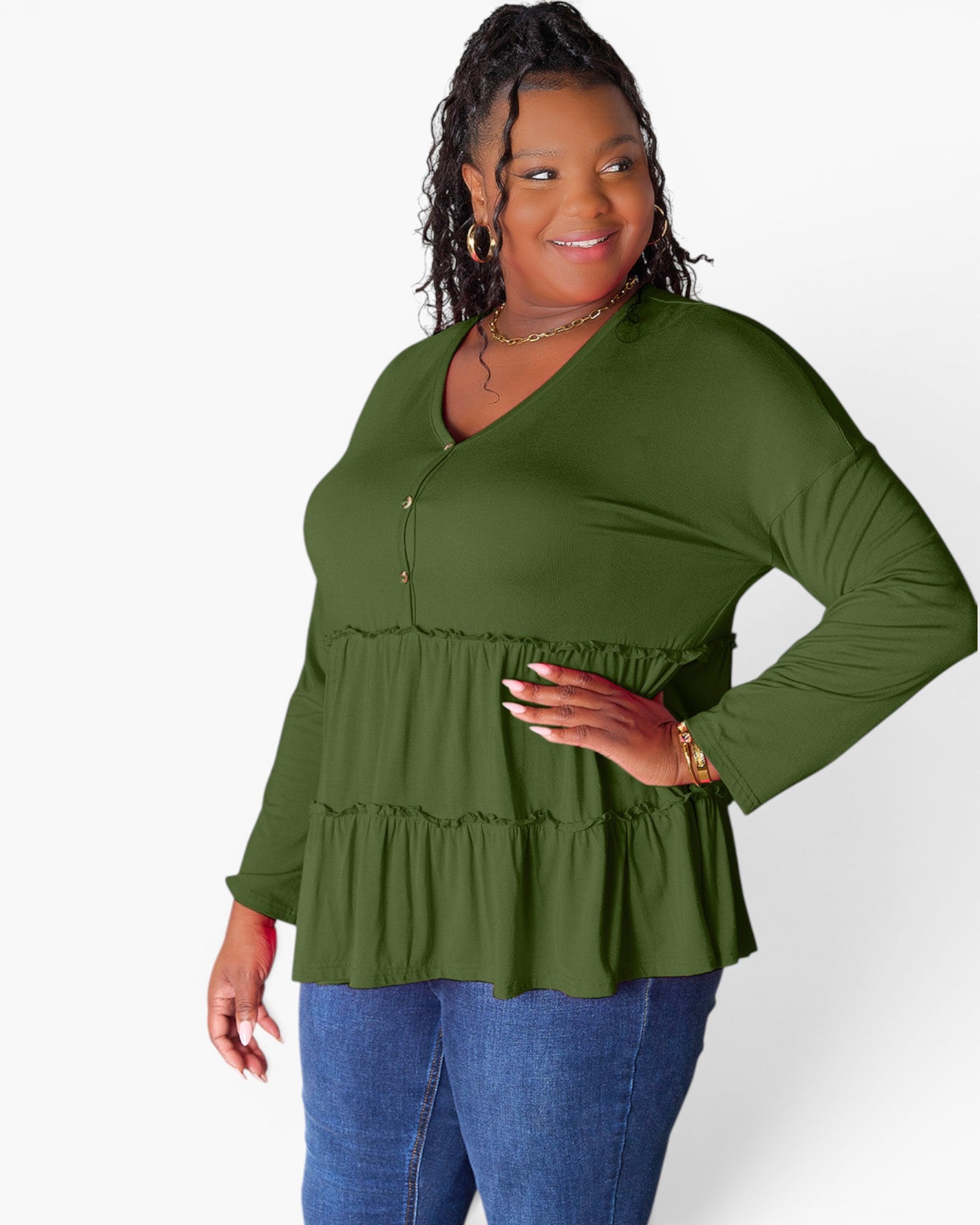 A woman modeling a long-sleeve olive green peplum top with a buttoned V-neckline, paired with blue jeans, against a plain white studio background.
