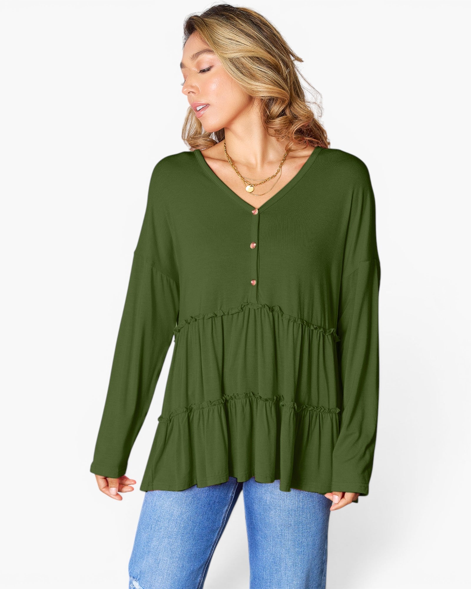 A woman wearing a long-sleeve olive green tiered blouse with a buttoned V-neckline, paired with blue jeans, against a plain white background.