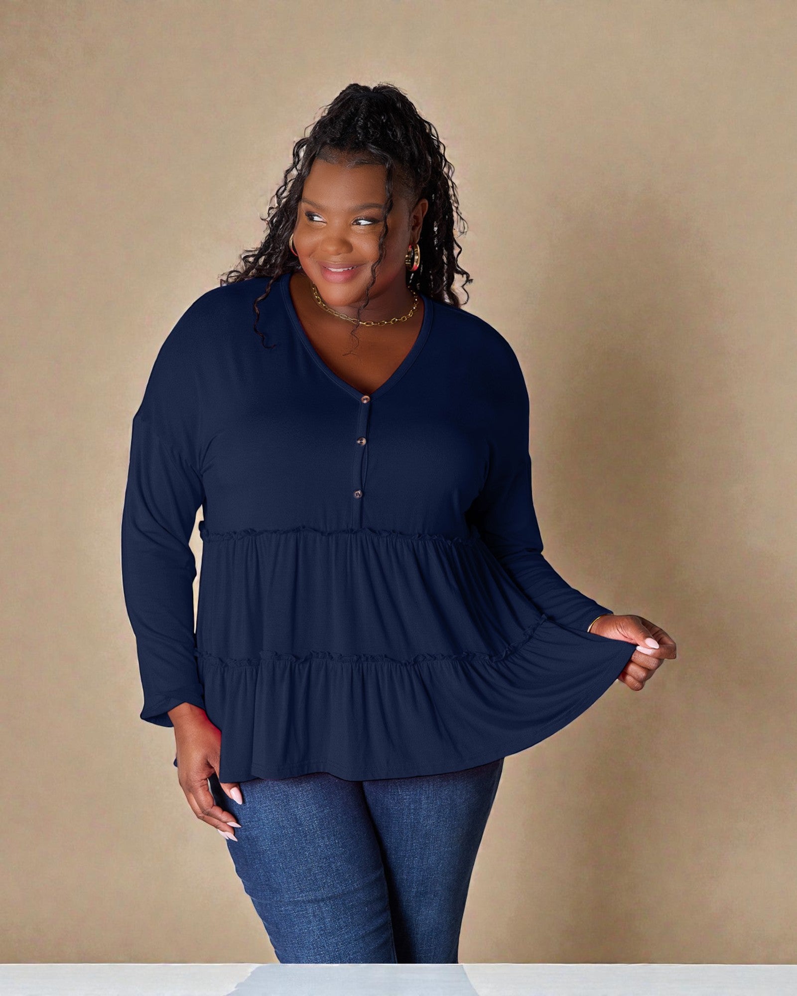Woman wearing a navy blue long-sleeve top against a beige background