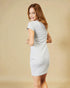 Woman wearing a light gray dress against a beige background