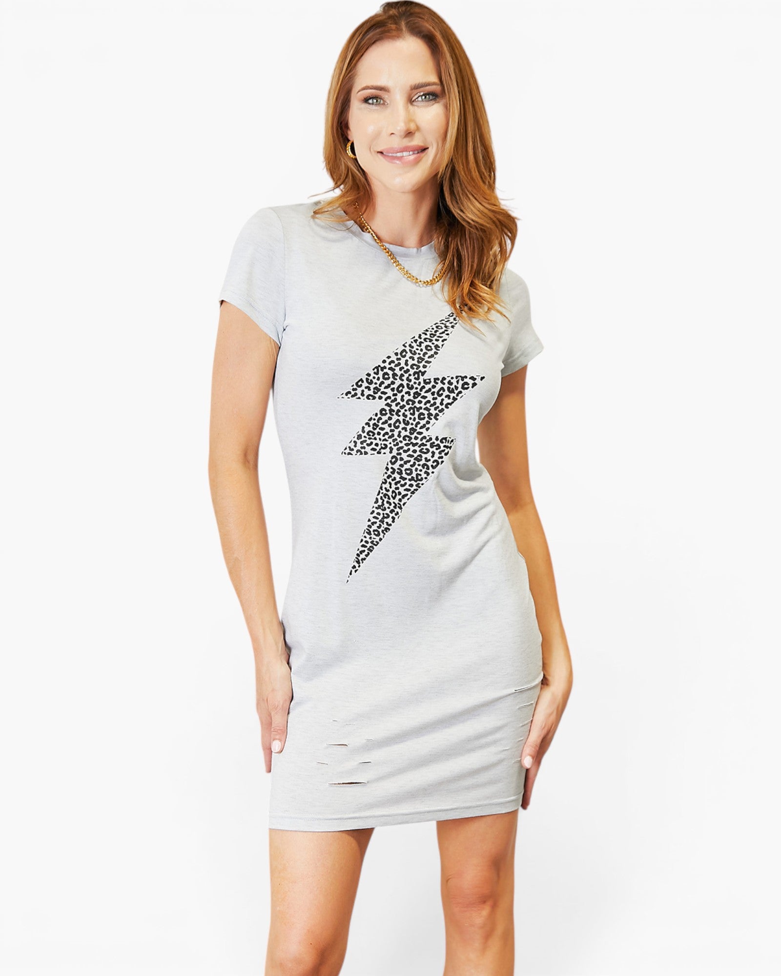 A woman modeling a light gray short-sleeve bodycon dress with a large black lightning bolt graphic on the front and distressed details near the hem, set against a plain white studio background.