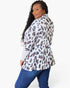 A woman modeling a white long-sleeve blazer with a navy and brown leopard print pattern, paired with blue jeans, against a plain white background.