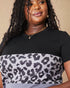 Woman wearing a black t-shirt with a leopard print design on a beige background