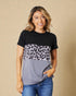 Woman wearing a black, gray, and leopard print top against a beige background