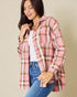 Woman wearing a pink and brown plaid shirt with a beige background