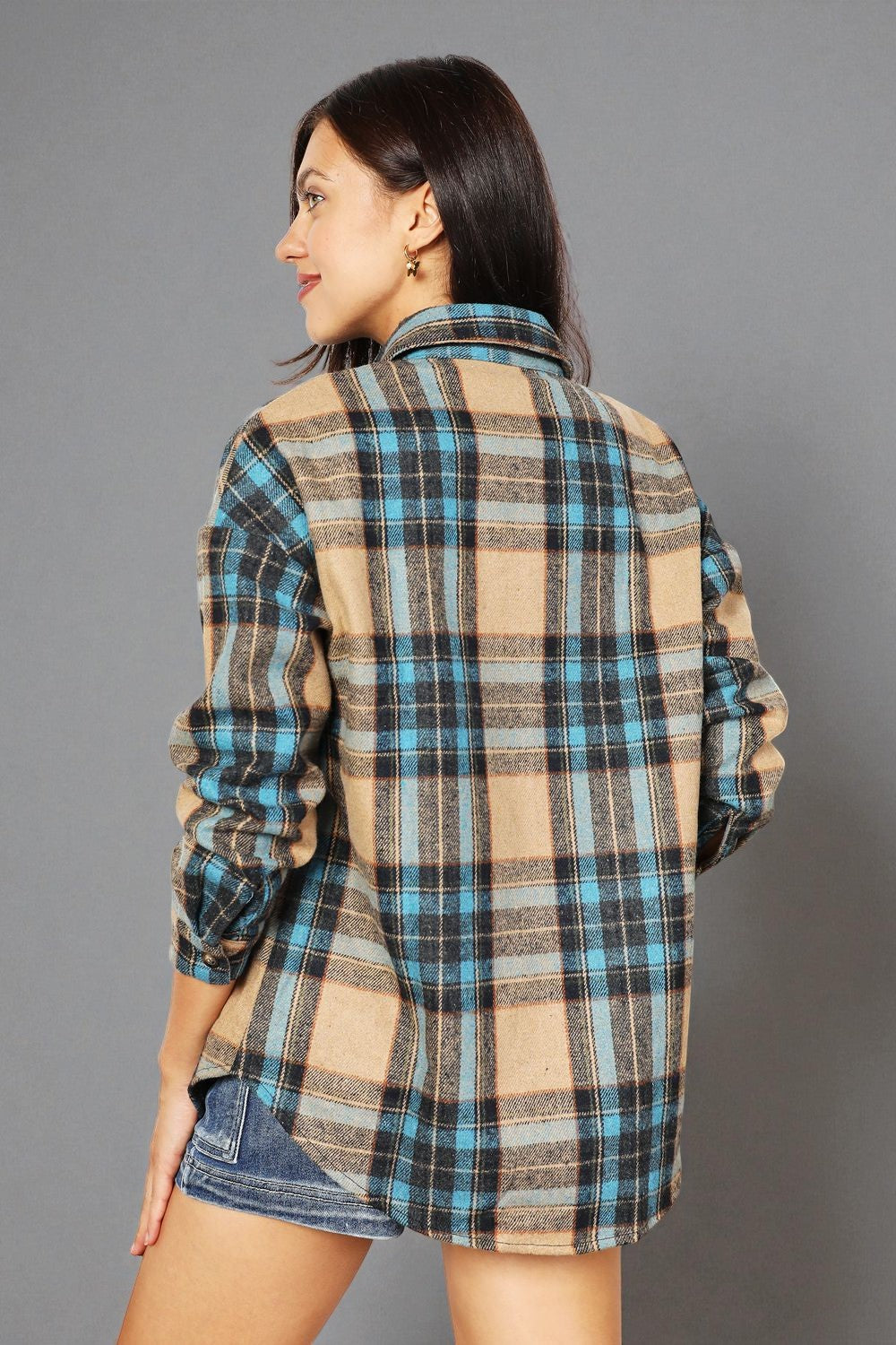 Woman wearing a plaid shirt with a gray background
