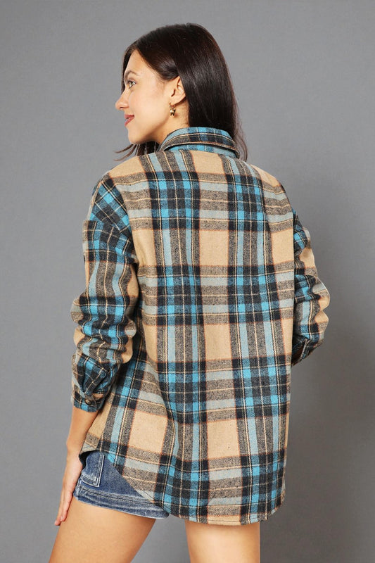 Woman wearing a plaid shirt with a gray background