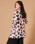 Woman wearing a floral blouse against a beige background