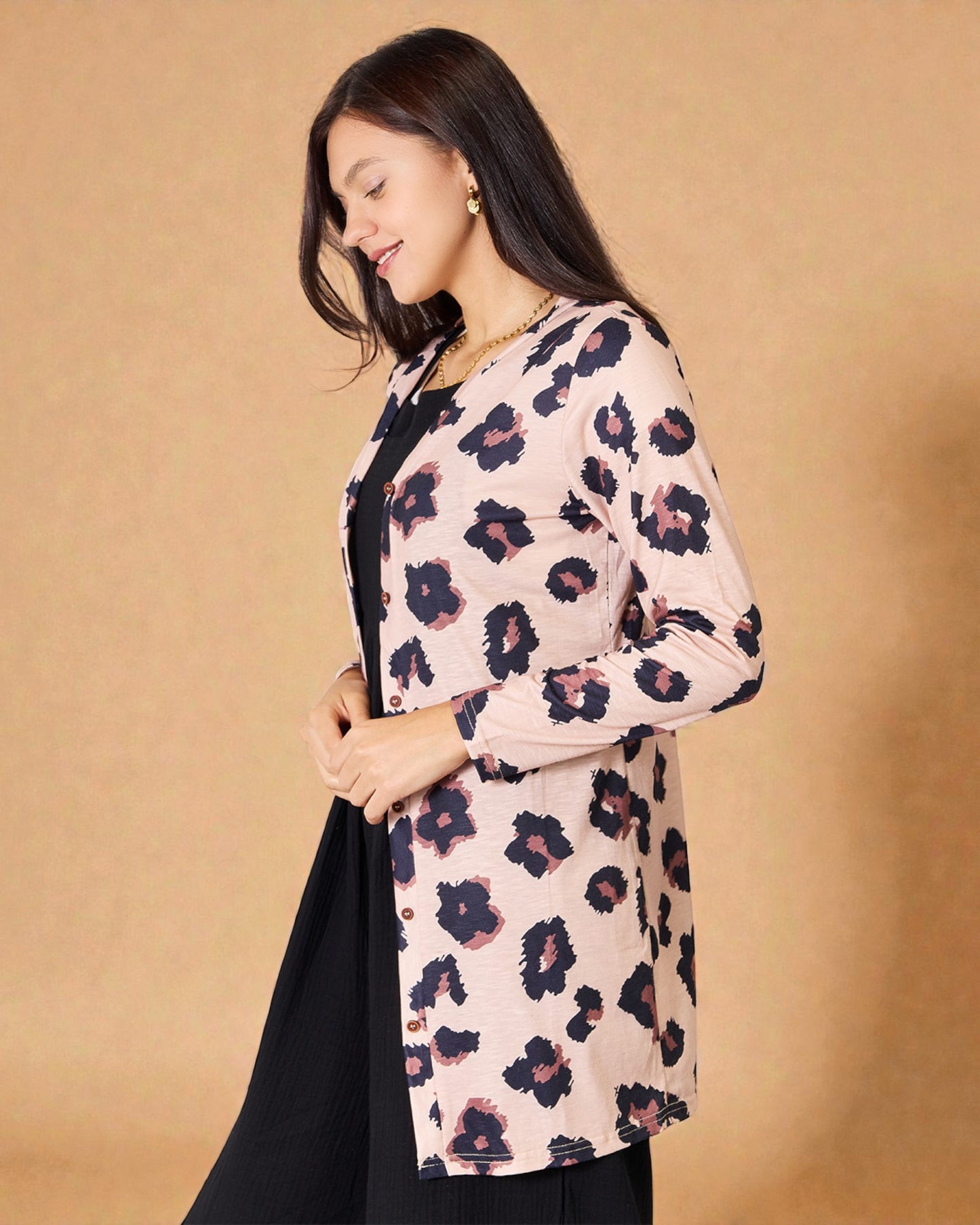 Woman wearing a floral cardigan against a beige background