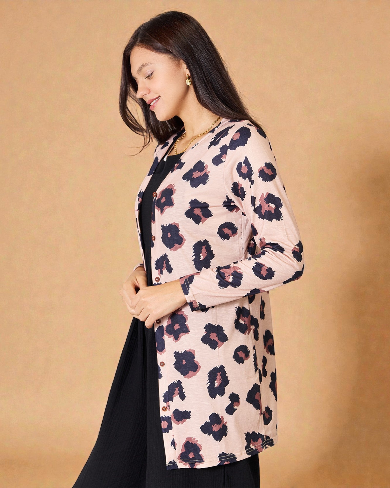 Woman wearing a floral cardigan against a beige background