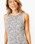 A woman wearing a sleeveless top with a black and white leopard print pattern and a light pink crew neckline, shown against a plain light gray background.