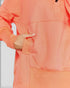 Close-up of a person wearing an orange hoodie with a blurred background