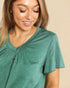 Woman wearing a green shirt with a beige background
