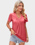 Woman wearing a pink top and denim shorts on a plain background