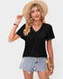 Woman wearing a black t-shirt, denim shorts, and a straw hat on a plain background
