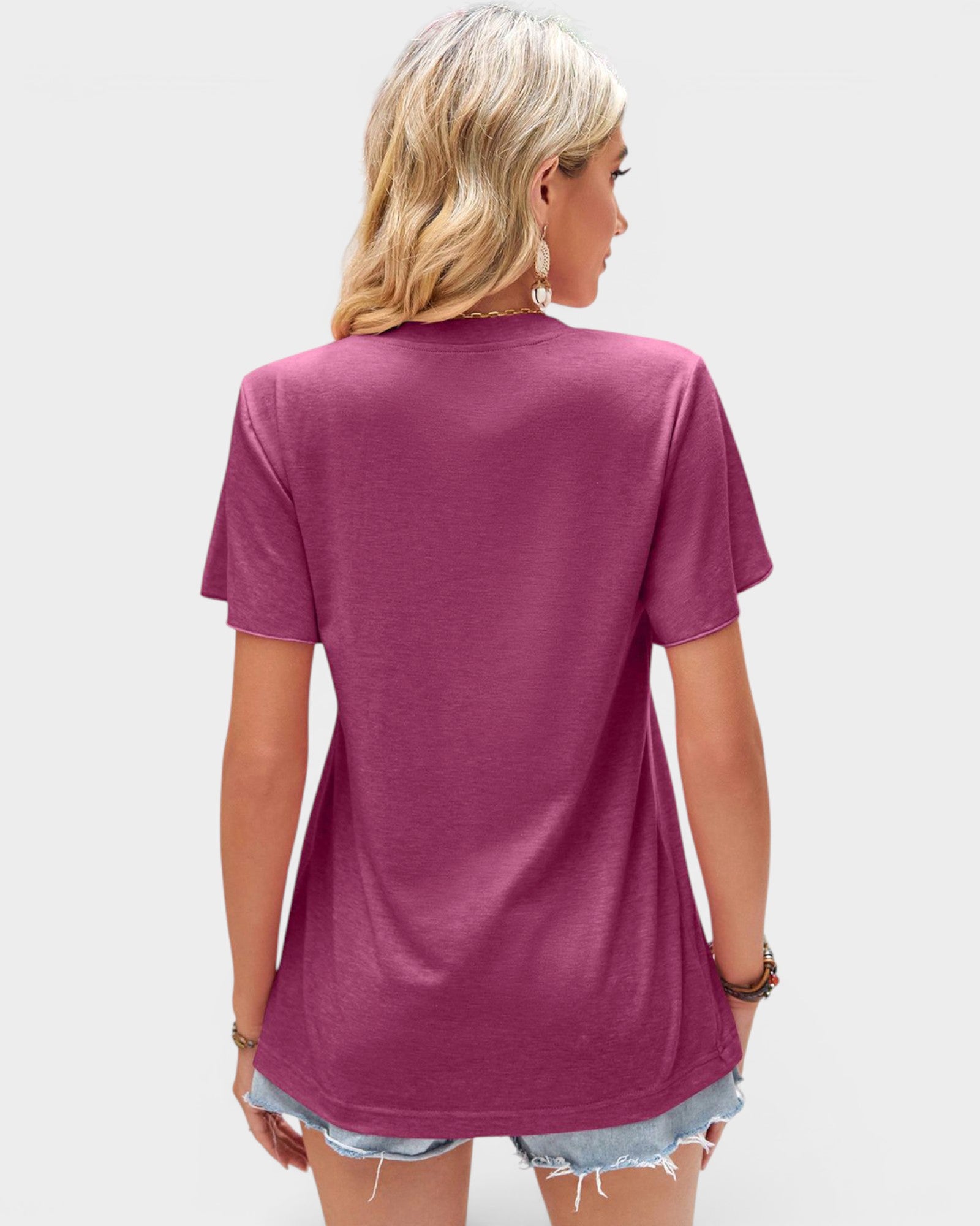 Person wearing a magenta t-shirt on a plain background