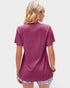 Person wearing a magenta t-shirt on a plain background