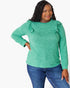A woman modeling a heather green long-sleeve top with ruffle details on the shoulders, paired with blue jeans, against a plain white background.