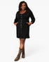 A woman modeling a black long-sleeve mini dress with a button-down front and side pockets, paired with brown cowboy boots, against a plain white studio background.