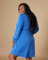 Woman wearing a blue dress against a beige background