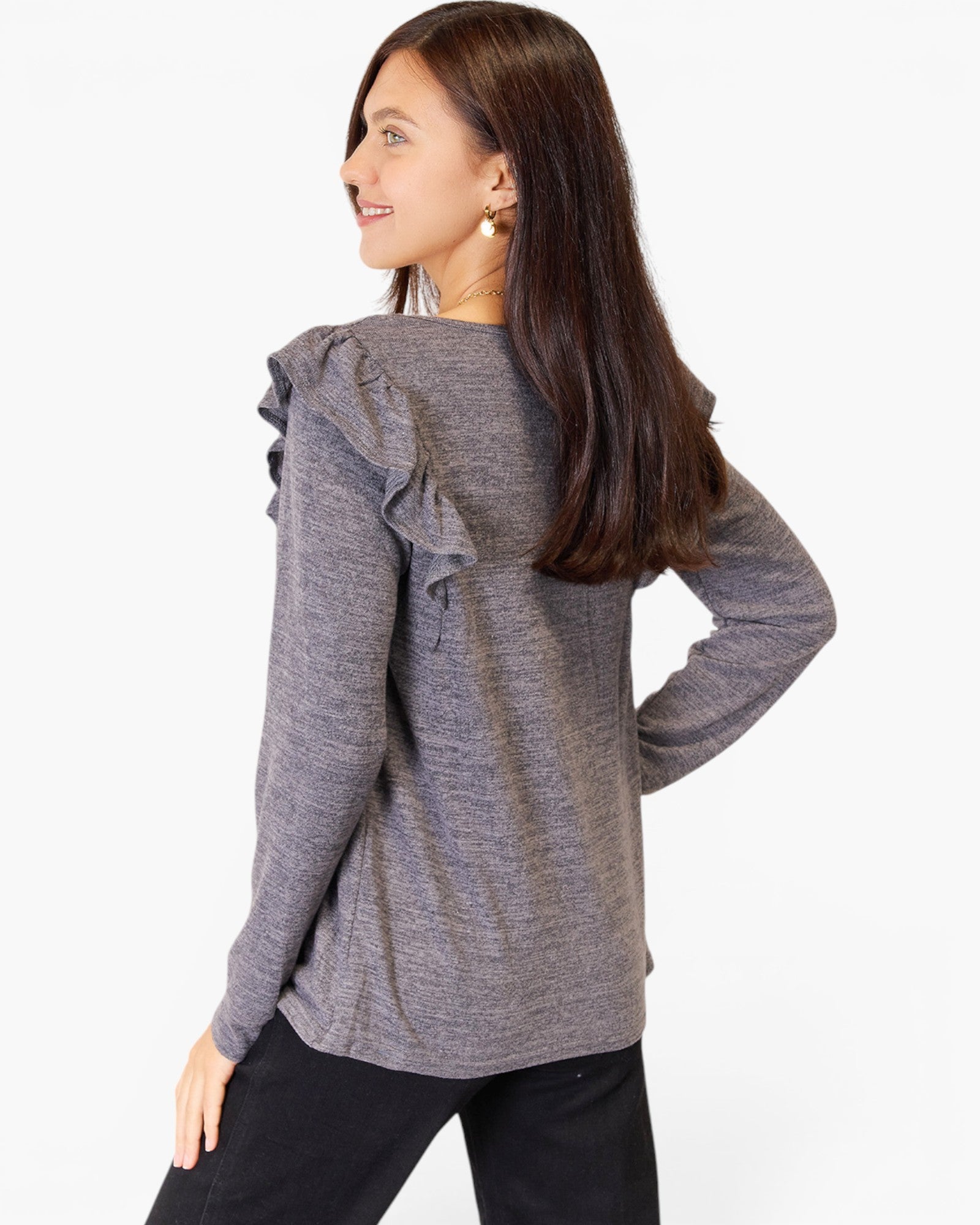 A woman wearing a heather gray long-sleeve top with ruffle details on the shoulders, shown from a three-quarter back view against a plain white background.