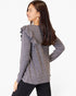A woman wearing a heather gray long-sleeve top with ruffle details on the shoulders, shown from a three-quarter back view against a plain white background.