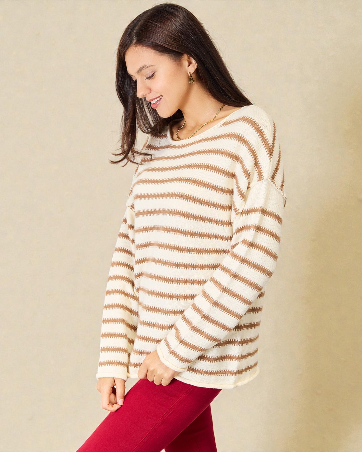Woman wearing a striped sweater against a beige background