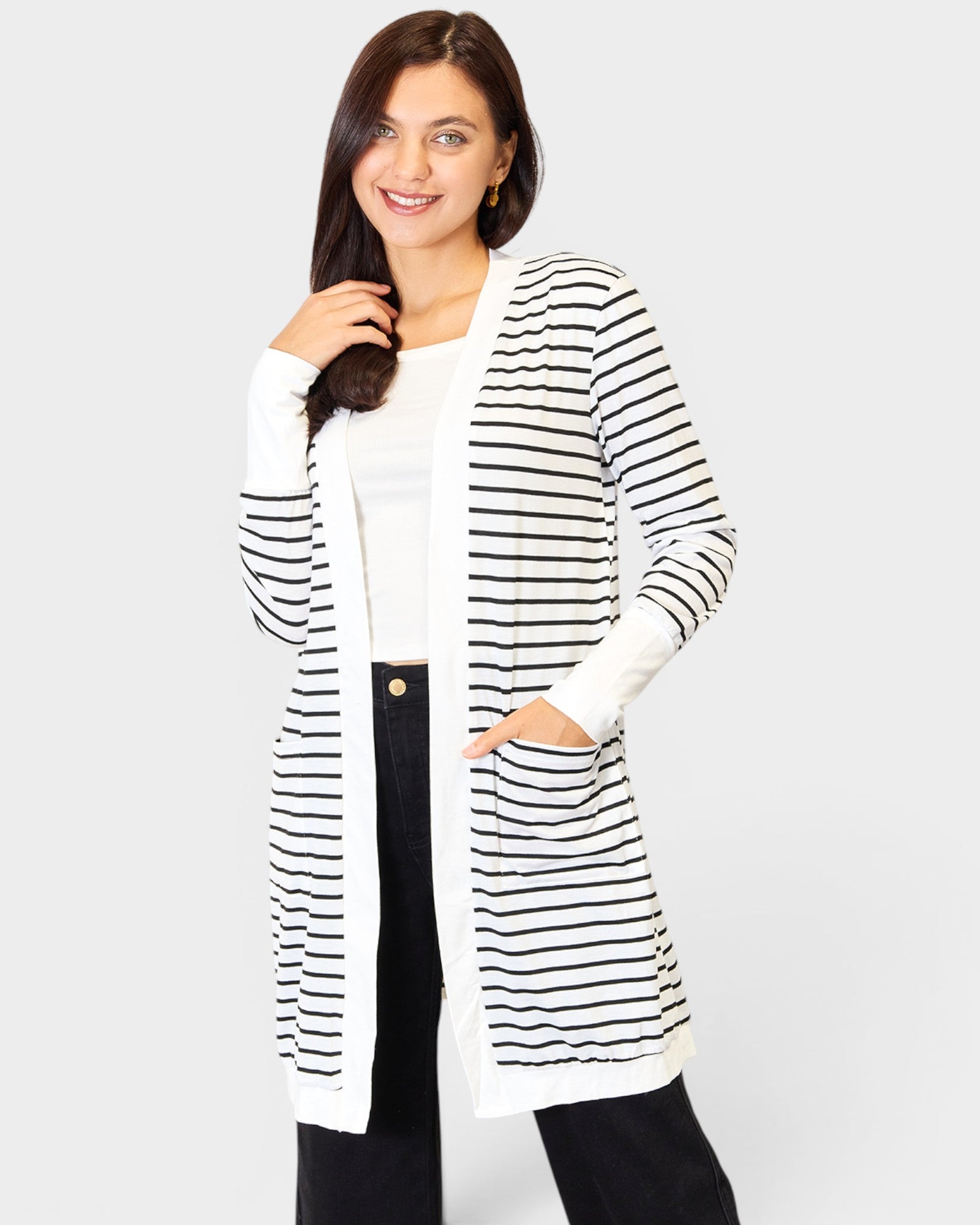 Woman wearing a black and white striped cardigan over a white shirt on a white background