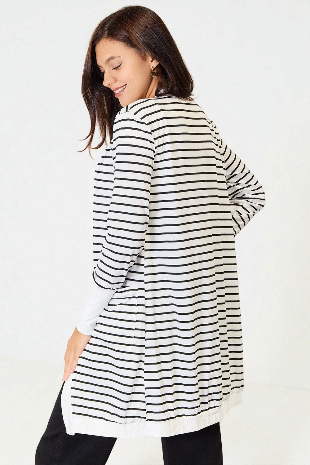 Woman wearing a black and white striped dress against a plain background
