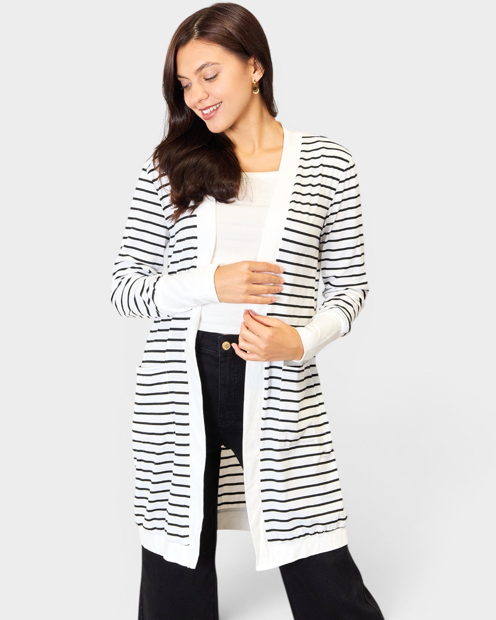 Woman wearing a black and white striped cardigan on a white background