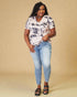 Woman wearing a tie-dye shirt and jeans on a beige background